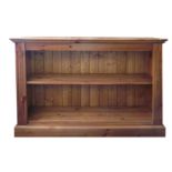A pair of pine low open bookcases, 20th Century, each with adjustable shelves on a plinth base,