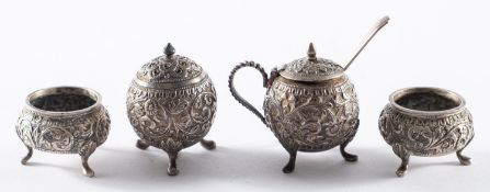 An Indian white metal four piece cruet set.