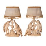 A pair of plaster groups of cavorting putti fitted as table lamps, 20th Century,