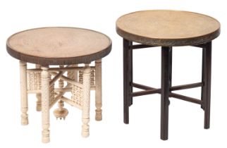 Three near eastern repousse work brass circular tiffin tables on stained or painted wood stands,