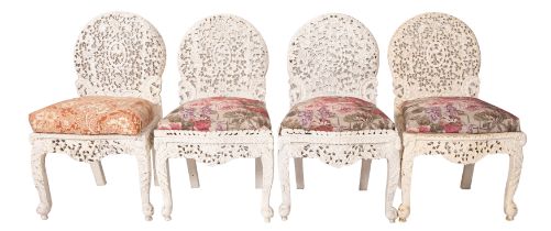 A set of four Anglo Indian carved hardwood and upholstered side chairs,