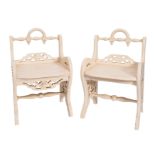 A pair of Edwardian later cream painted stools with low turned rail backs and solid seats,