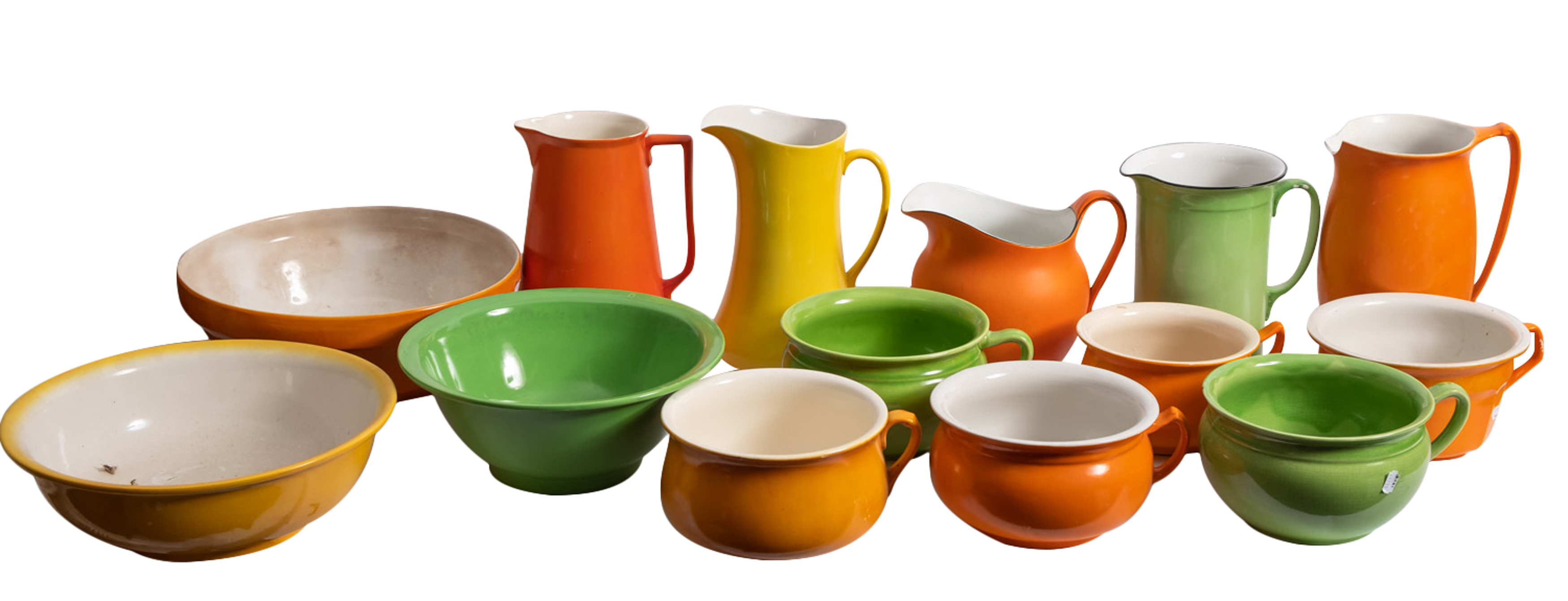 A collection of Staffordshire glazed pottery chamberwares in bright colours of orange,