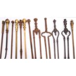 A quantity of wrought iron and brass mounted fire tools, 19th century; including various pokers,