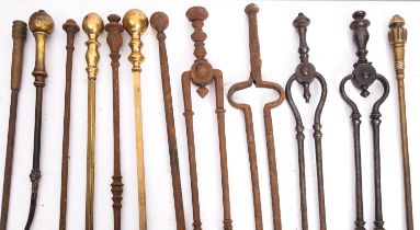 A quantity of wrought iron and brass mounted fire tools, 19th century; including various pokers,