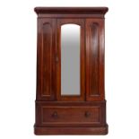 A Victorian mahogany wardrobe with a moulded cornice enclosed by a central mirror panel,