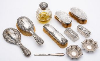 A group of silver mounted dressing table items including: a cut glass globular scent bottle,