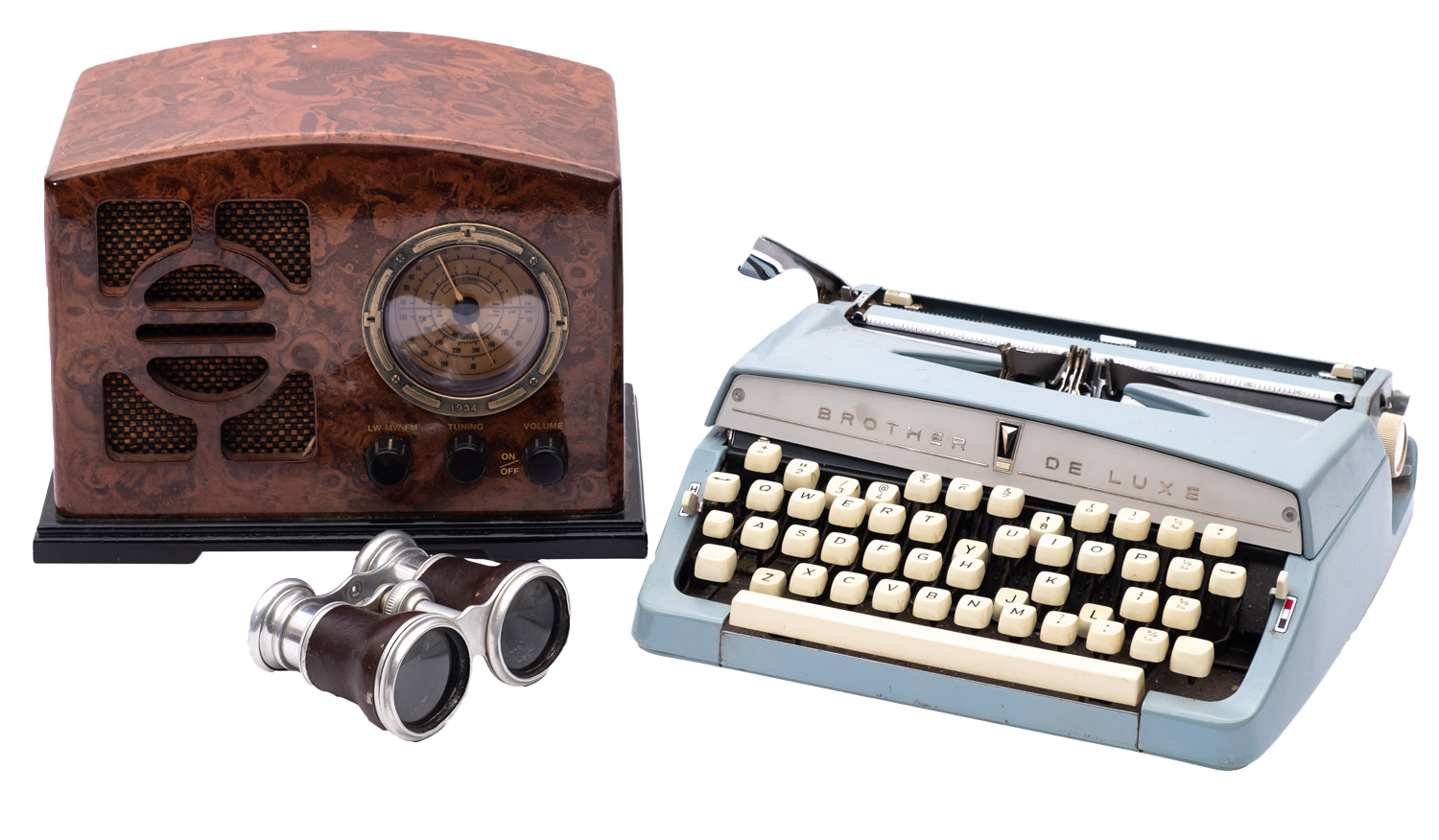 A Brother Deluxe typewriter together with a pair of opera glasses and a simulated bakelite radio.