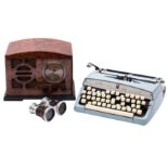 A Brother Deluxe typewriter together with a pair of opera glasses and a simulated bakelite radio.