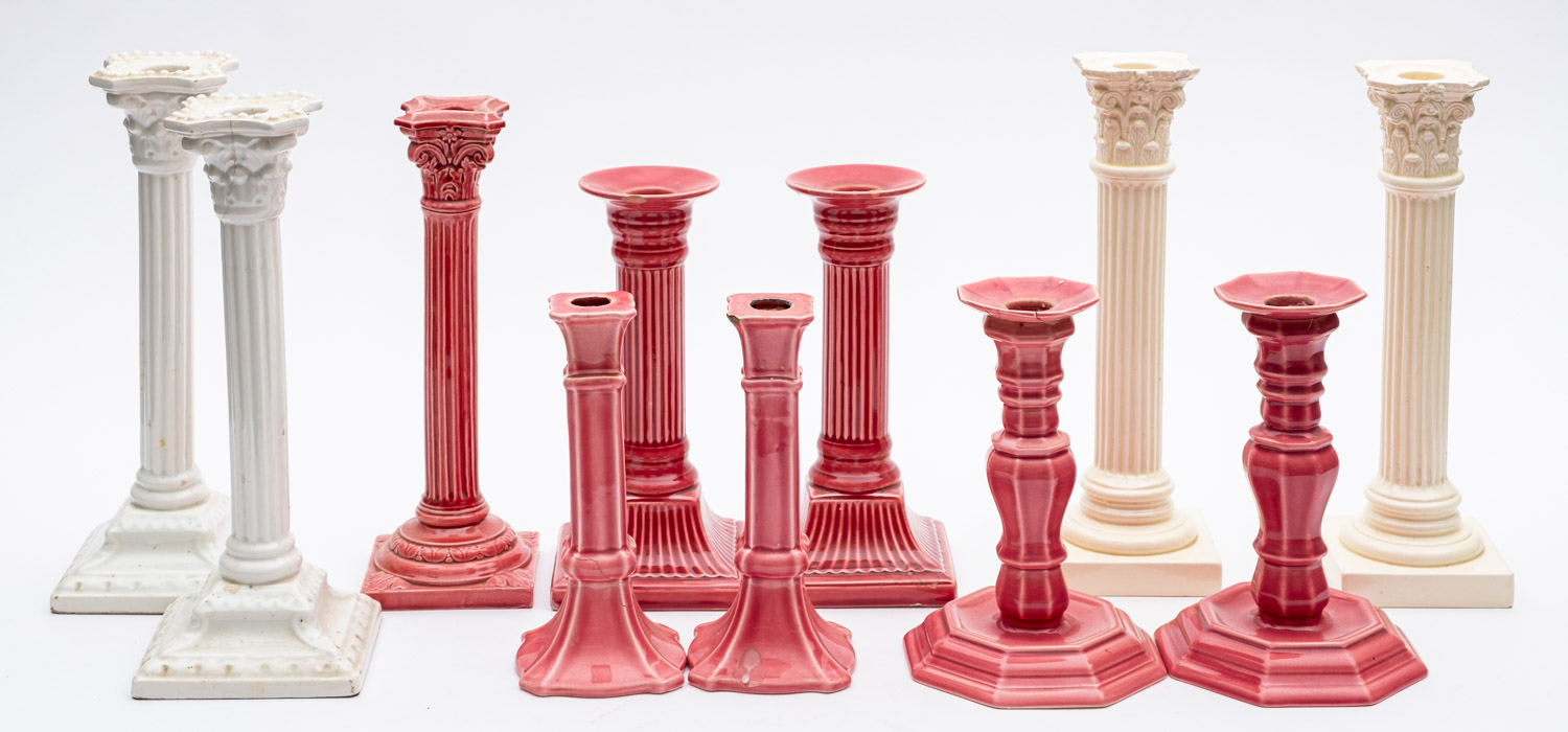 Five pairs of white and pink glazed candlesticks and one single candlestick.