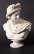 A Parian ware classical bust of Apollo, on circular socle, inscribed 'C DELPECH',