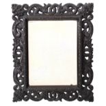 A carved and stained ebonised wood rectangular mirror, late 19th Century,