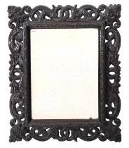 A carved and stained ebonised wood rectangular mirror, late 19th Century,