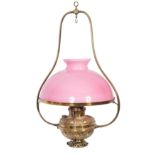A late Victorian/Edwardian brass hanging oil lantern, with pink opaque glass shade,