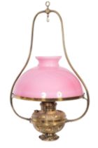 A late Victorian/Edwardian brass hanging oil lantern, with pink opaque glass shade,