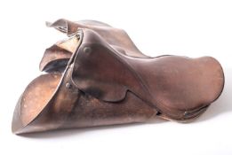 Three brown leather saddles and one child's saddle (4)