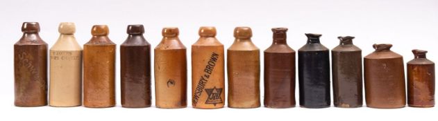 A collection of five salt glazed stoneware bottles; Schweppes, Dawes Table Water, A.