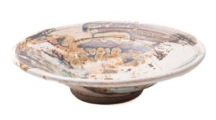 Kyra Cane [b. 1962] a stoneware shallow bowl of circular form under arbitrary soda glazes,