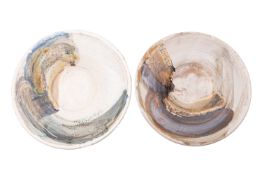 Kyra Cane [b. 1962] two stoneware chargers of circular form under arbitrary soda glazes,