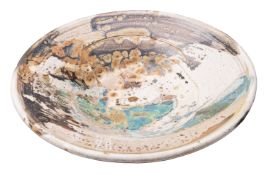 Kyra Cane [b. 1962] a stoneware shallow bowl of circular form under arbitrary soda glazes