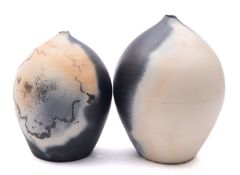 Two white stoneware vases of oviform tapering to a narrow neck with smoke fired variegated