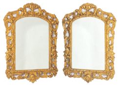 A pair of carved and giltwood framed wall mirrors in 18th Century taste, probably Spanish,