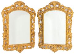 A pair of carved and giltwood framed wall mirrors in 18th Century taste, probably Spanish,