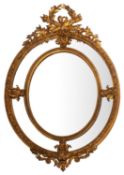 A giltwood and composition framed oval marginal wall mirror in Louis XV taste,