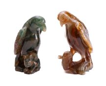 An Oriental agate carving and one similar both in the form of a hawk with one claw resting on a