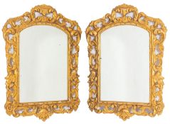 A pair of carved and giltwood framed wall mirrors in 18th Century taste, probably Spanish,