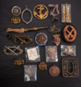 A small collection of various badges, shoulder flashes, a belt buckle and similar items.