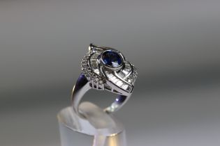 A contemporary Sapphire and Diamond Cluster Ring,the oval shaped central sapphire with rub over