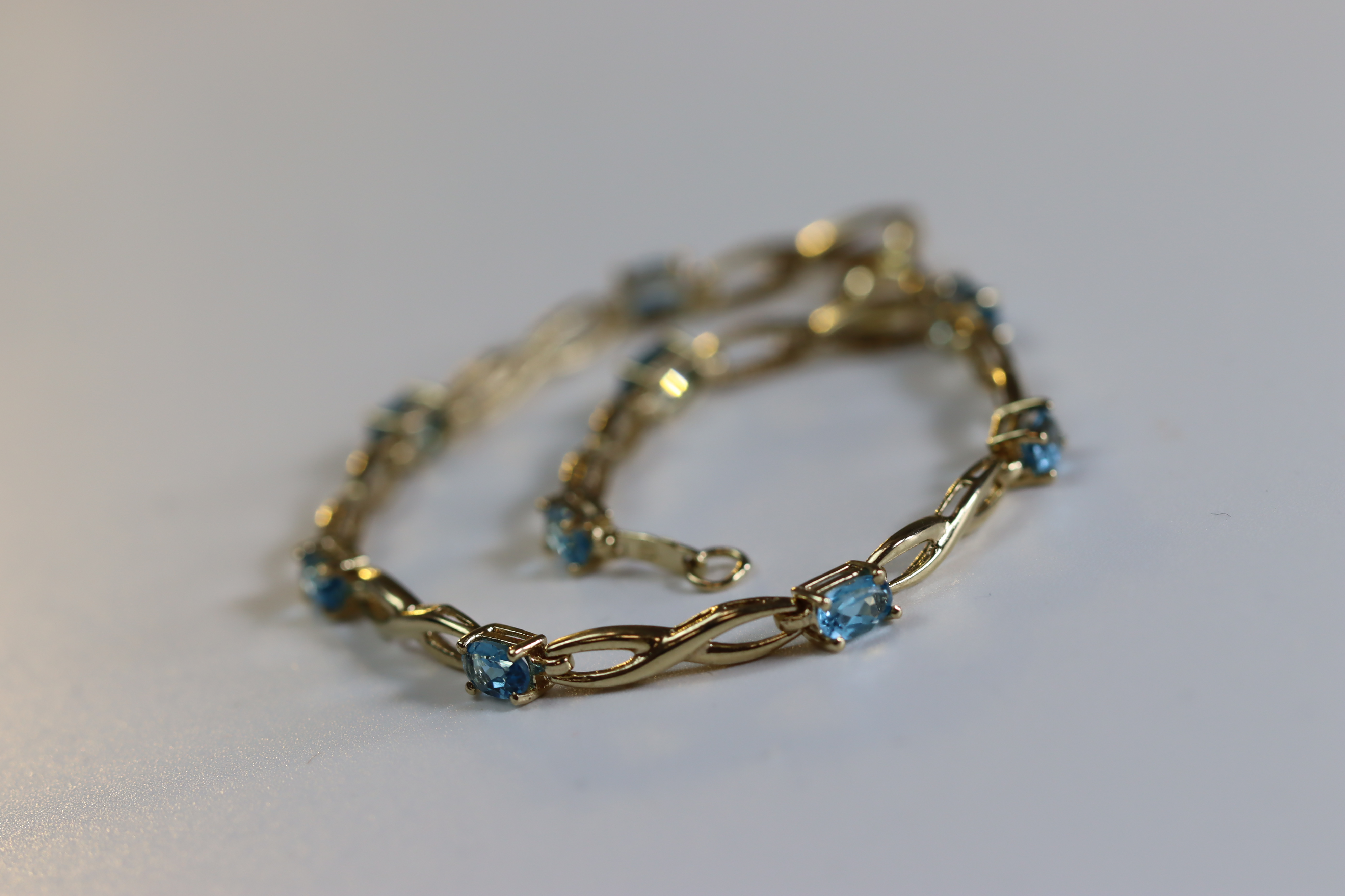 A Blue Topaz and Yellow Metal Line Bracelet A Blue Topaz and Yellow Metal Line Bracelet, set with