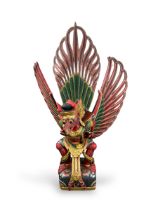 A wood carving of Garuda. Indonesia.A large polychrome wooden figure depicting Garuda perched on a