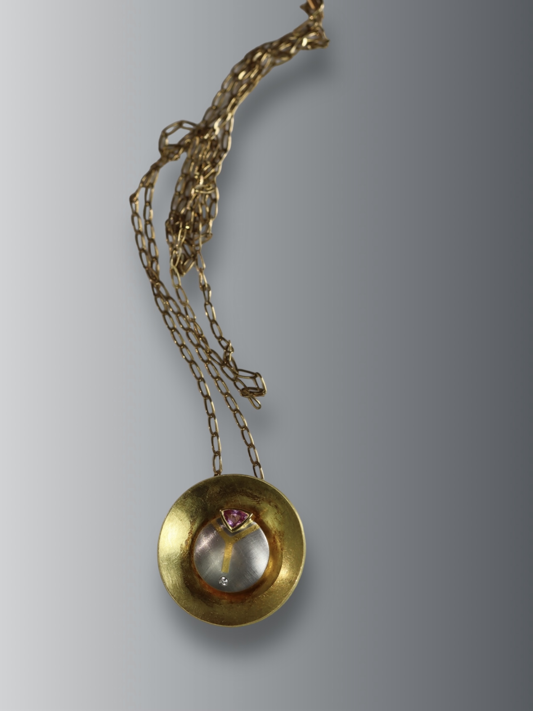 An Unusual Gold, Platinum, Diamond and Ruby Disc Pendant, on a long chain, chain set in 9 ct gold,