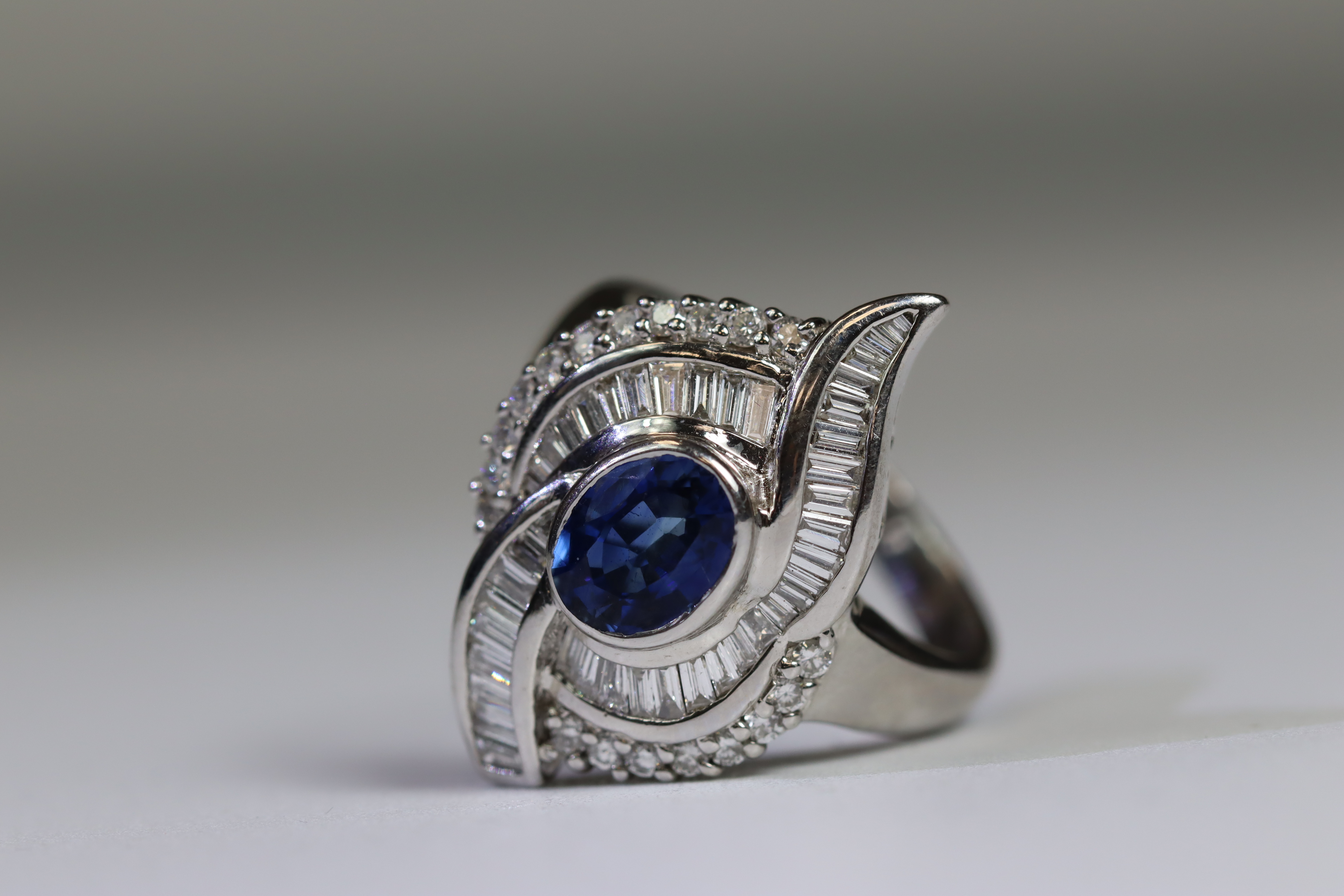 A contemporary Sapphire and Diamond Cluster Ring,the oval shaped central sapphire with rub over - Image 10 of 16