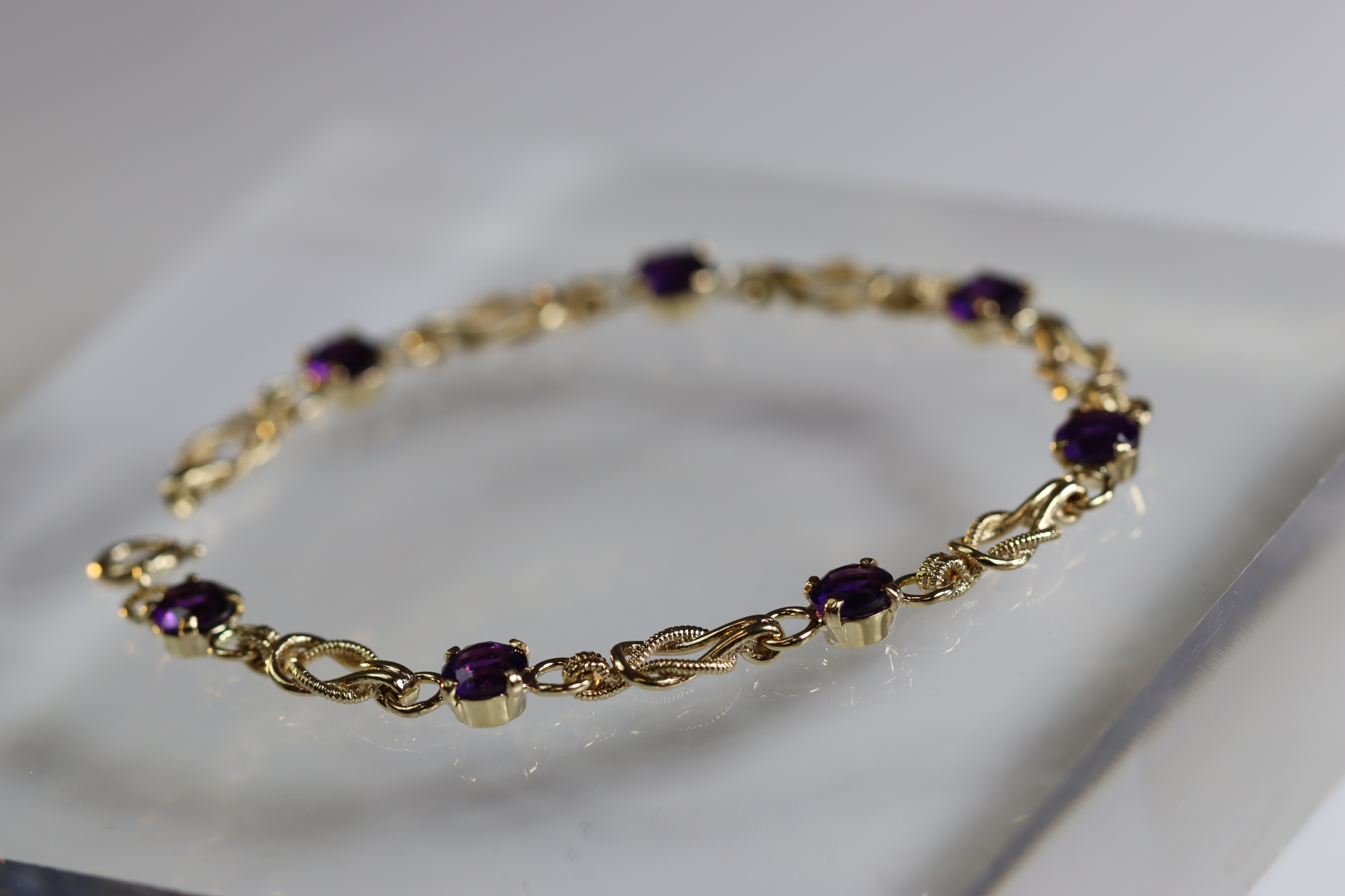 An Amethyst and 9 Carat Yellow Gold Line Bracelet set with seven circular mixed cut amethysts, - Image 3 of 8