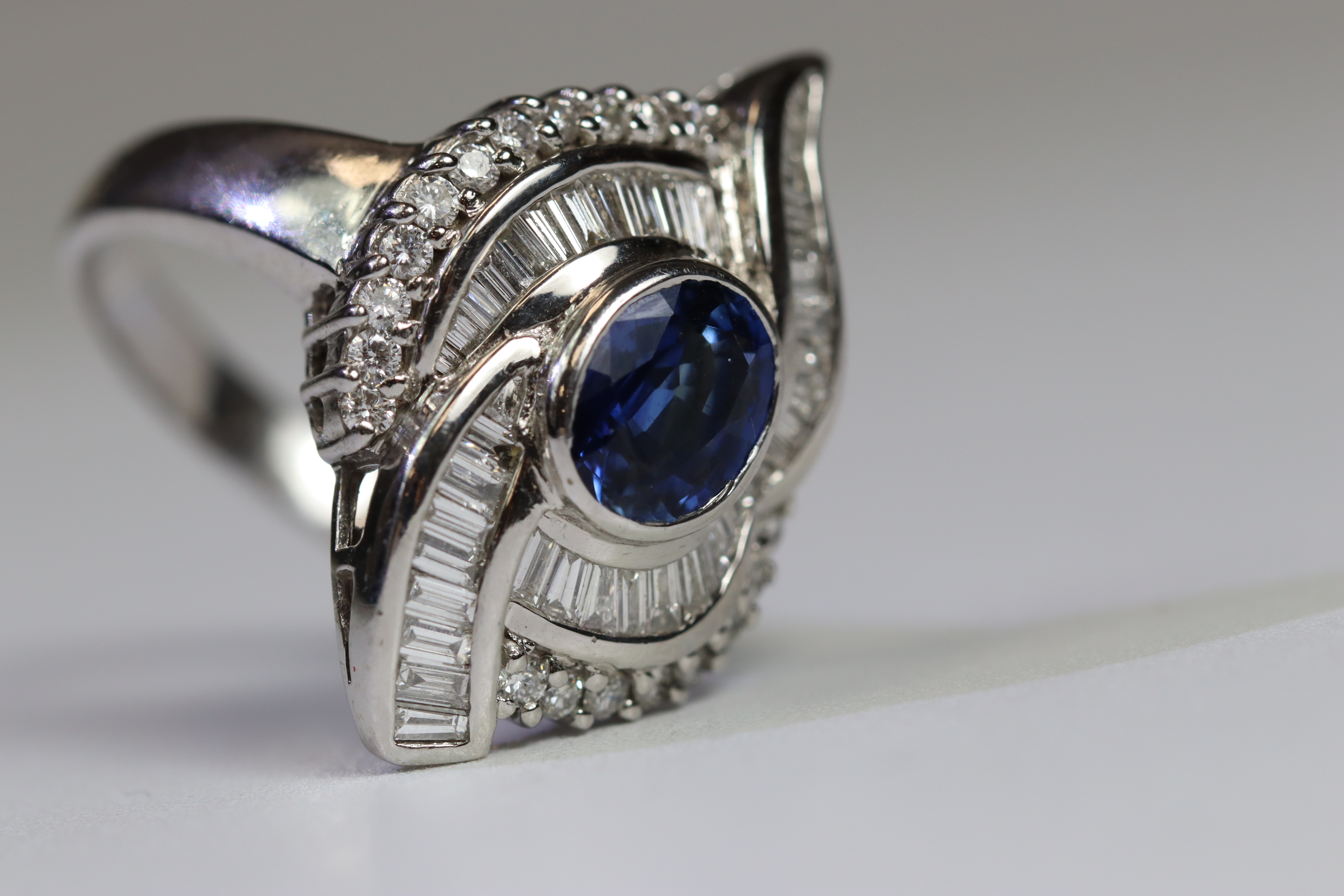 A contemporary Sapphire and Diamond Cluster Ring,the oval shaped central sapphire with rub over - Image 9 of 16