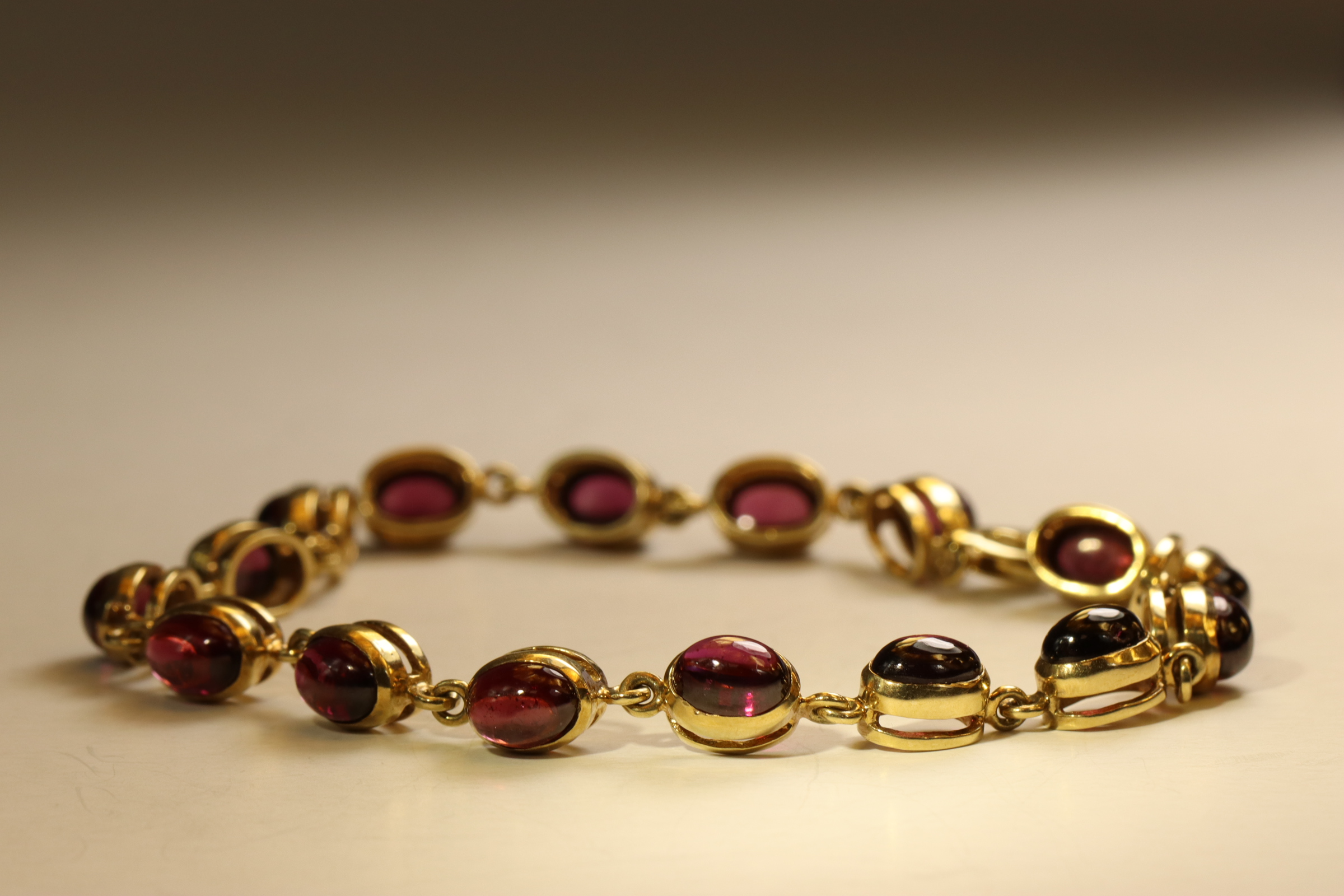 A Cabochon Garnet and 9 ct Yellow Gold Bracelet, Composed of sixteen oval shaped cabochon - Image 2 of 5