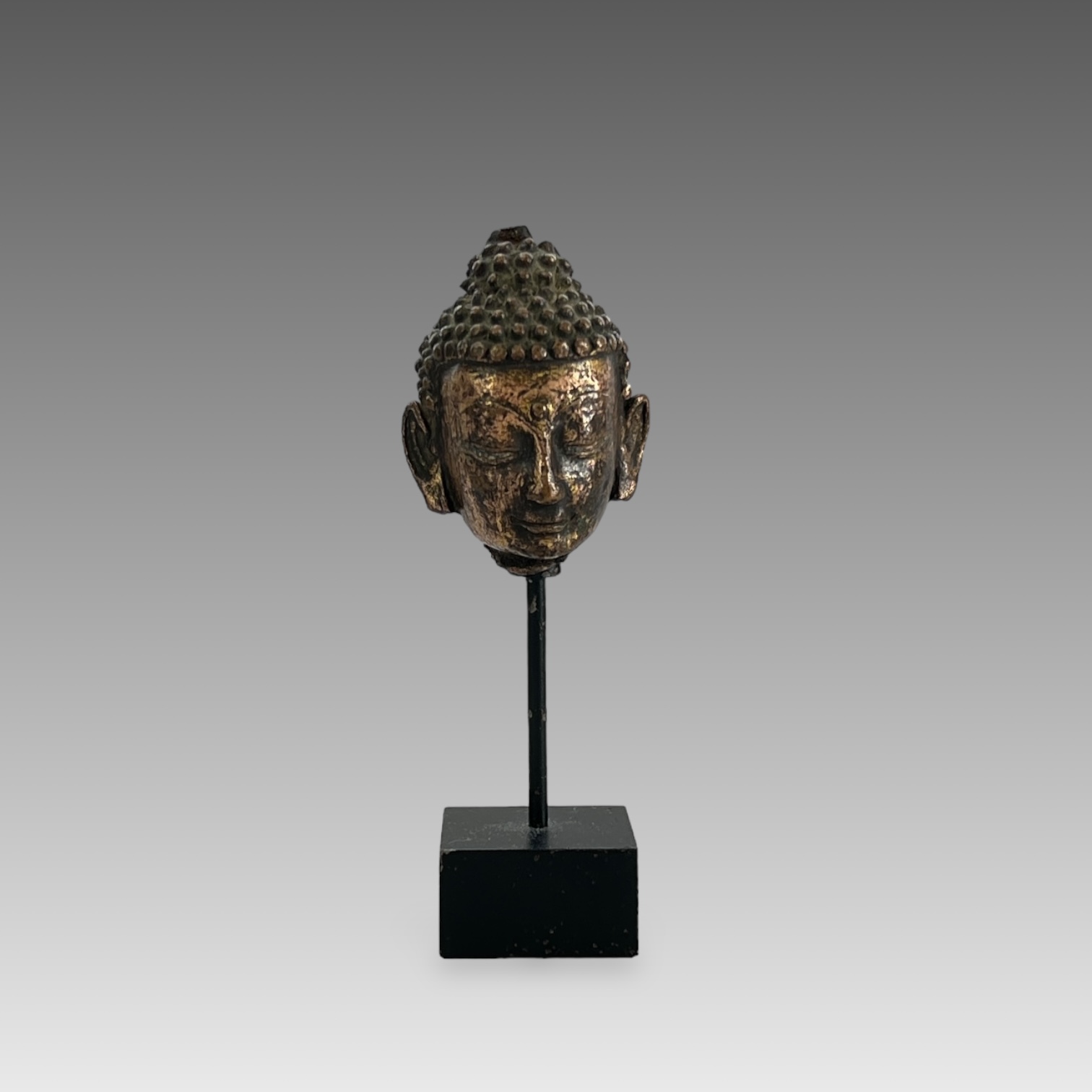 A Gilt Bronze Head of Buddha, 13th centurysensitively modelled with serene downcast gaze, still with