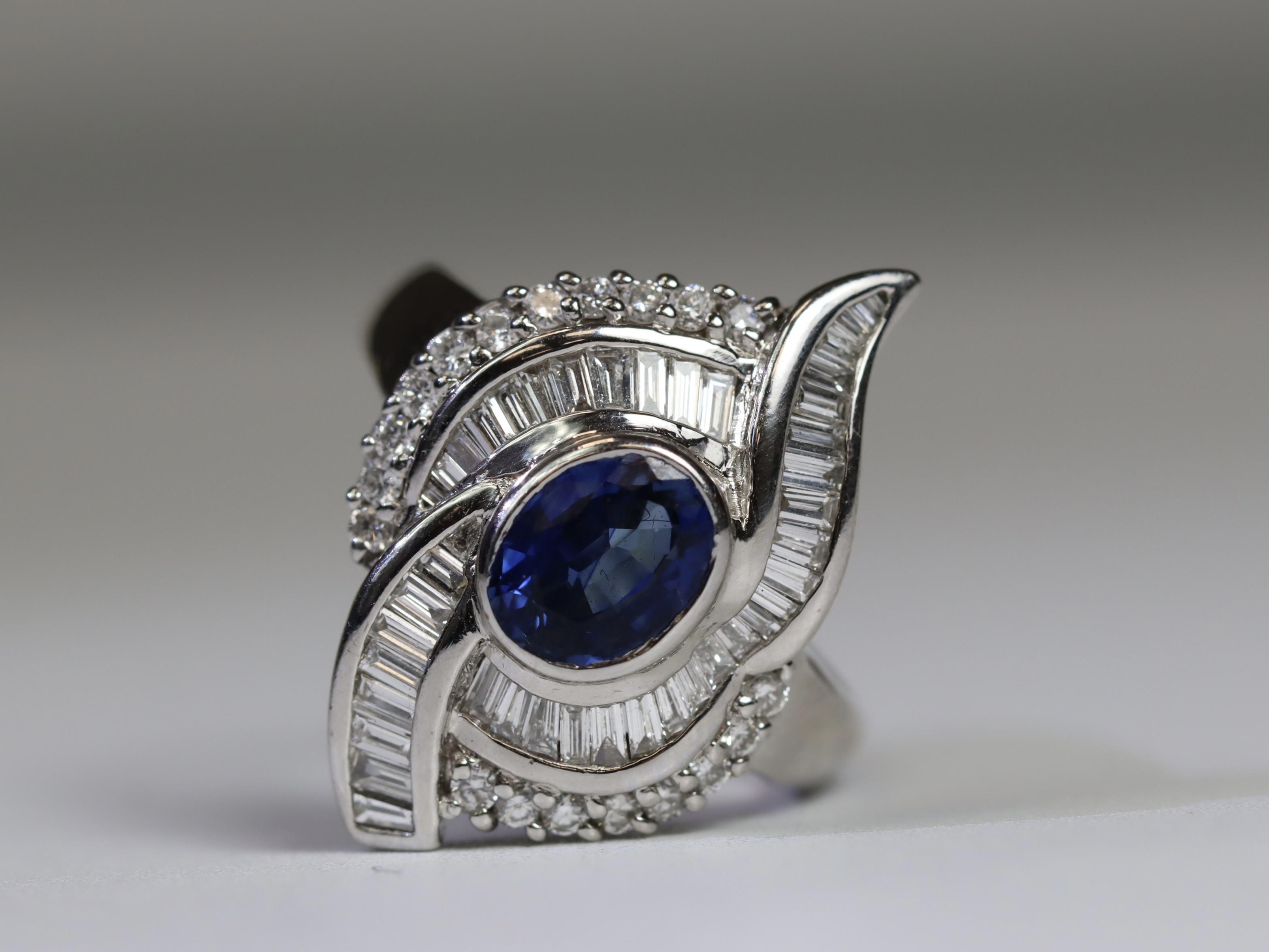 A contemporary Sapphire and Diamond Cluster Ring,the oval shaped central sapphire with rub over - Image 13 of 16