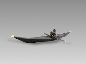 An Inuit Kayak Model. Artic Canada ca. Late 19th Century.A good kayak model and figurine made of