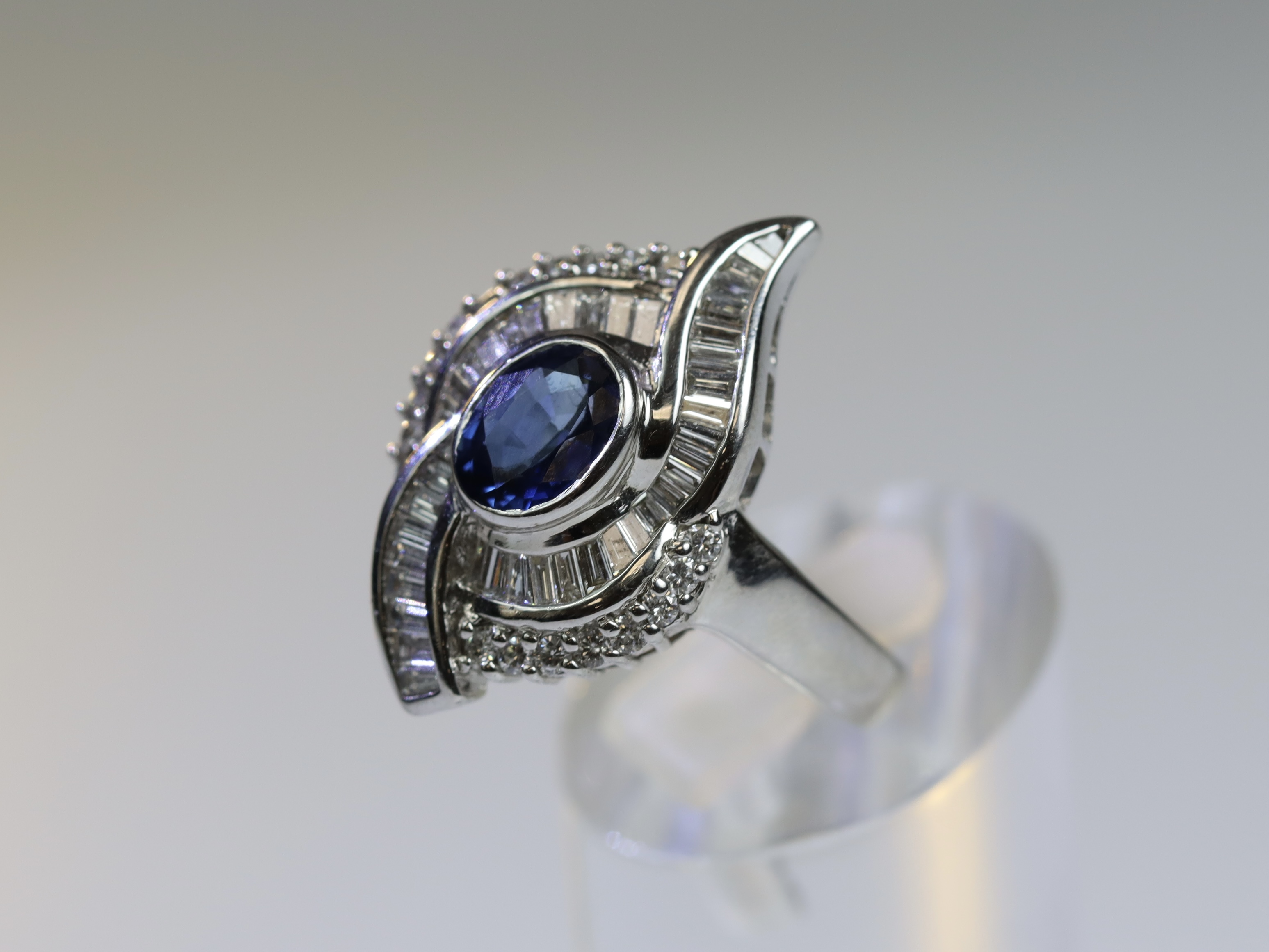 A contemporary Sapphire and Diamond Cluster Ring,the oval shaped central sapphire with rub over - Image 2 of 16