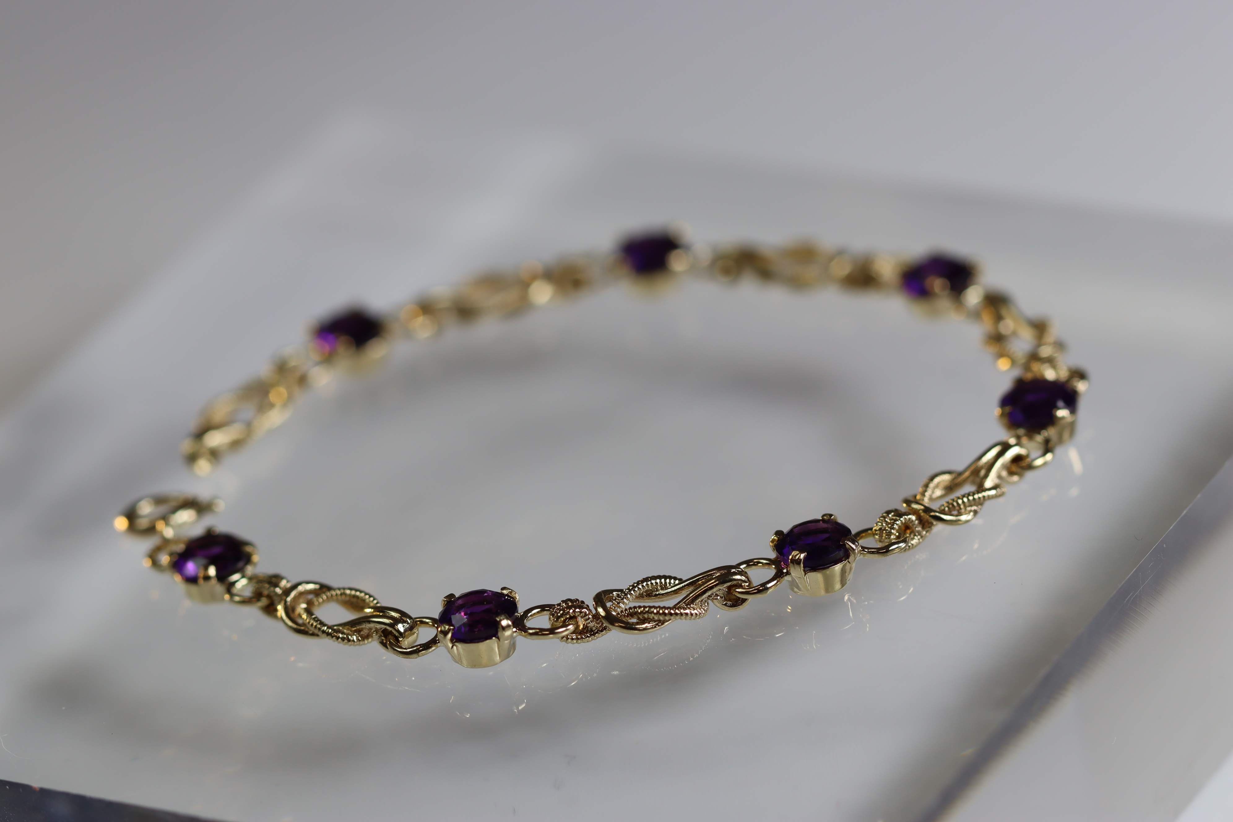 An Amethyst and 9 Carat Yellow Gold Line Bracelet set with seven circular mixed cut amethysts, - Image 6 of 8