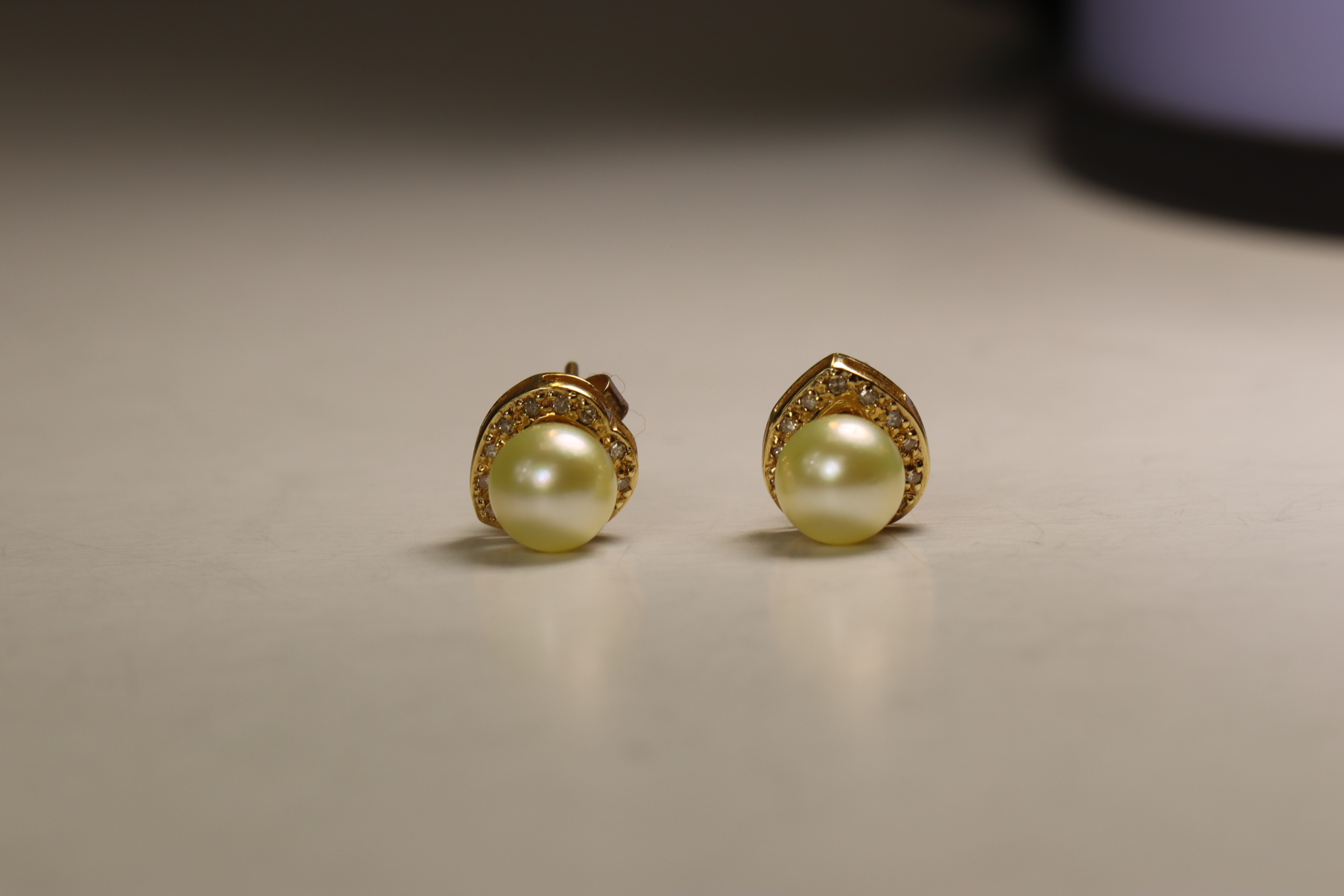 A Pair of Cultured Pearl and Diamond Earstuds,  The single stone cultured pearls within small