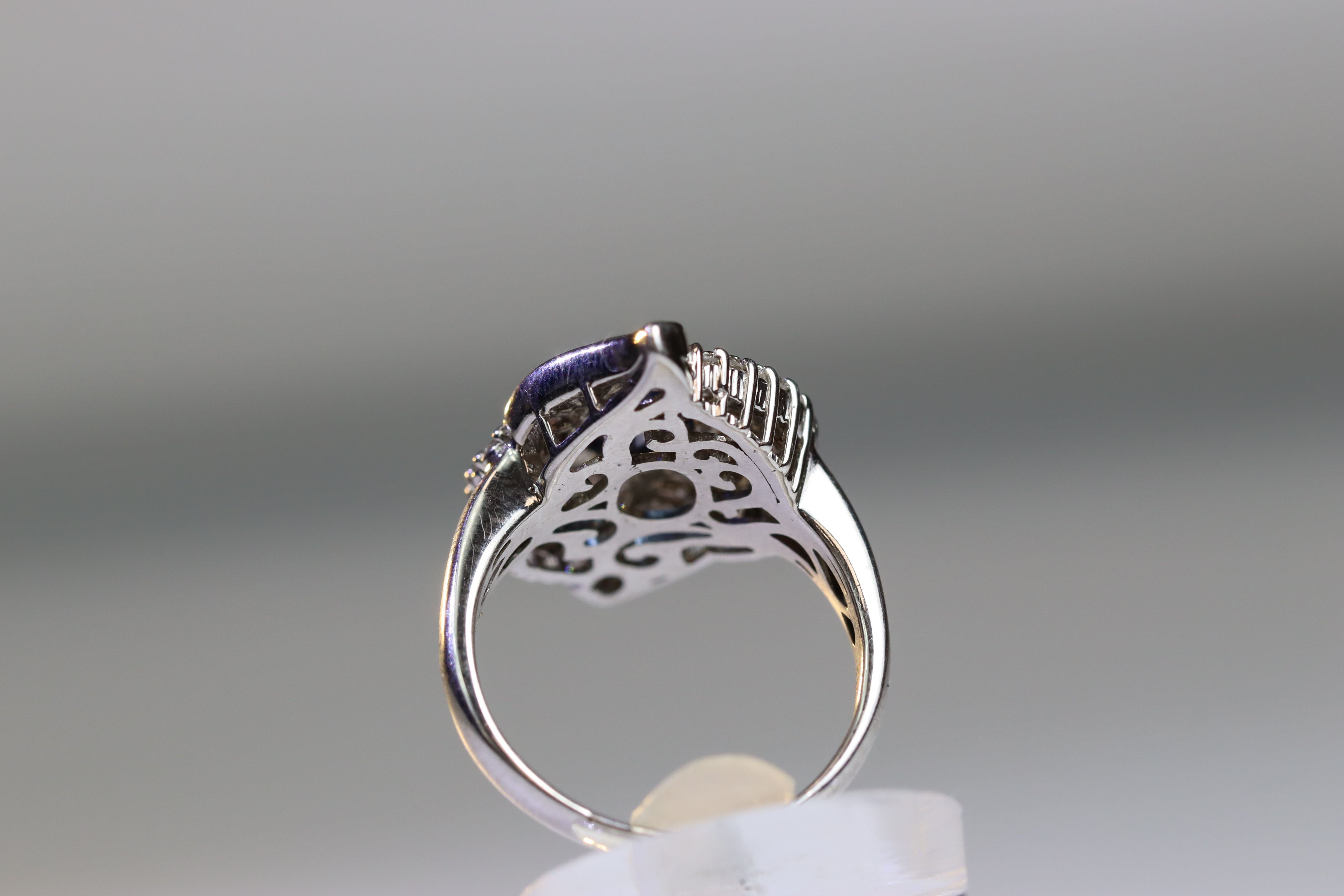 A contemporary Sapphire and Diamond Cluster Ring,the oval shaped central sapphire with rub over - Image 4 of 16