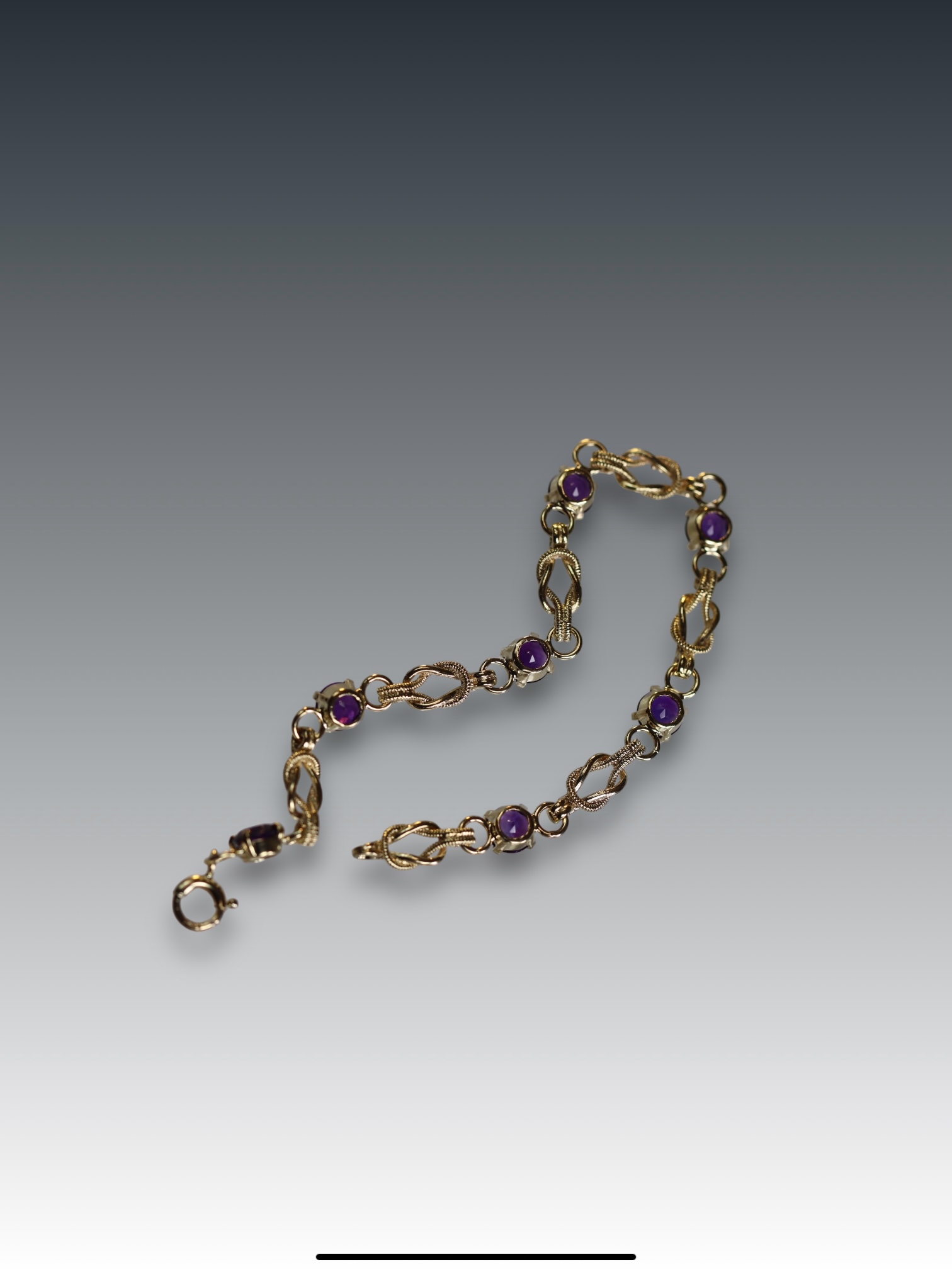 An Amethyst and 9 Carat Yellow Gold Line Bracelet set with seven circular mixed cut amethysts,