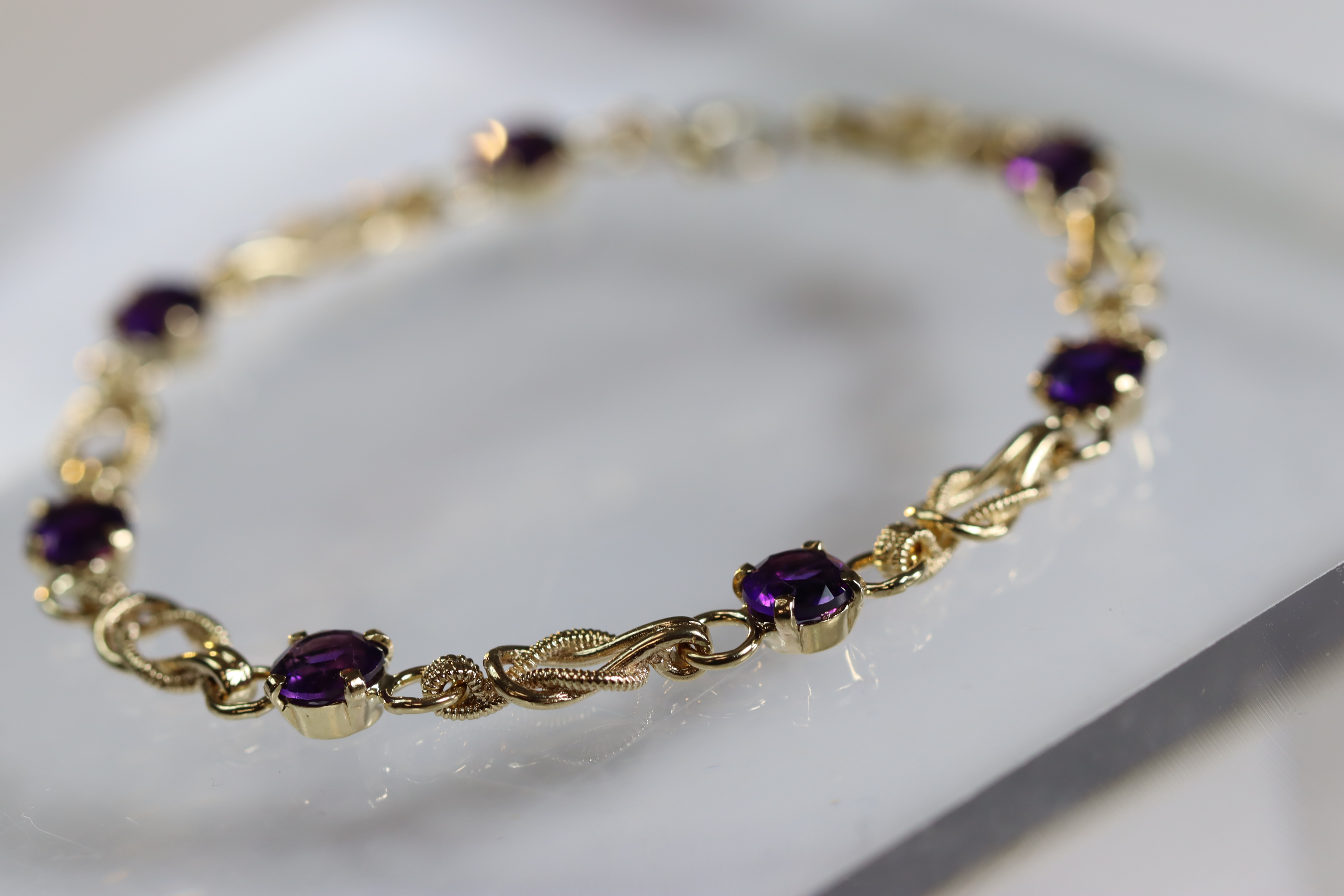 An Amethyst and 9 Carat Yellow Gold Line Bracelet set with seven circular mixed cut amethysts, - Image 2 of 8