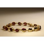 A Cabochon Garnet and 9 ct Yellow Gold Bracelet, Composed of sixteen oval shaped cabochon