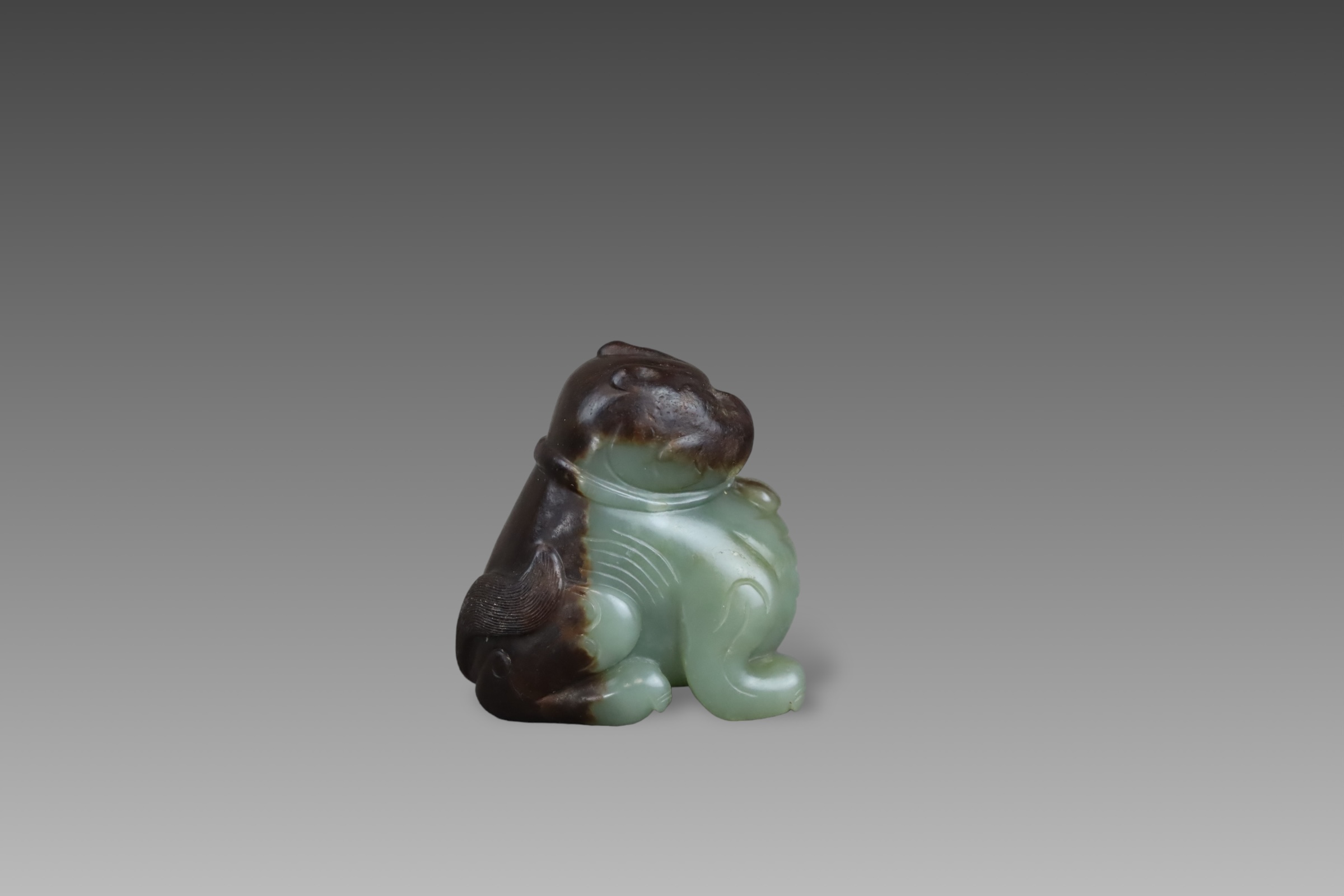 A Green and Brown Jade Seated Lion, Ming dynasty,
